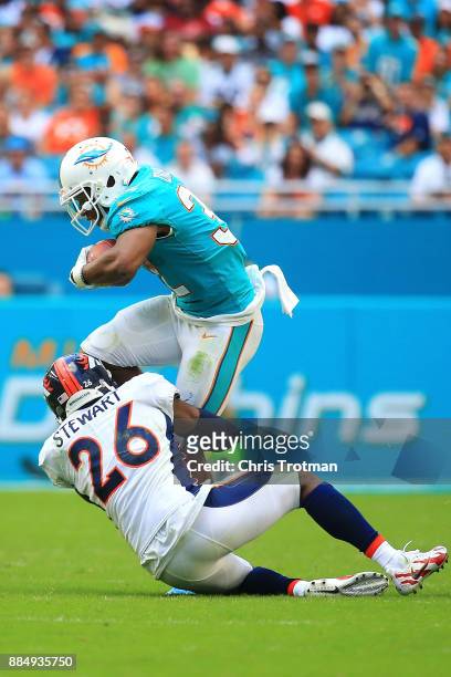 Darian Stewart of the Denver Broncos tackles Kenyan Drake of the Miami Dolphins during the third quarter at the Hard Rock Stadium on December 3, 2017...
