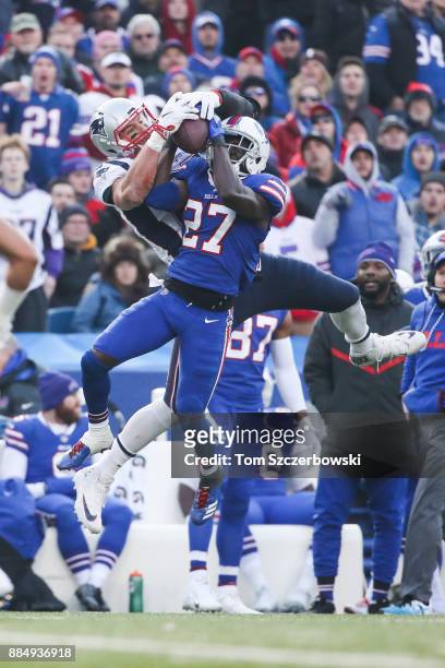 Rob Gronkowski of the New England Patriots and Tre'Davious White of the Buffalo Bills attempt to catch the ball during the fourth quarter on December...