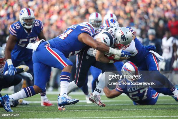 Eddie Yarbrough of the Buffalo Bills and Micah Hyde of the Buffalo Bills tackle Rex Burkhead of the New England Patriots during the fourth quarter on...