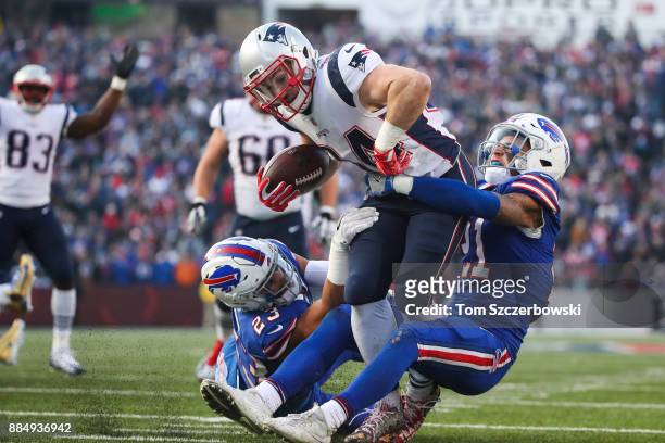 Rex Burkhead of the New England Patriots scores a touchdown as Micah Hyde of the Buffalo Bills and Jordan Poyer of the Buffalo Bills attempt to...