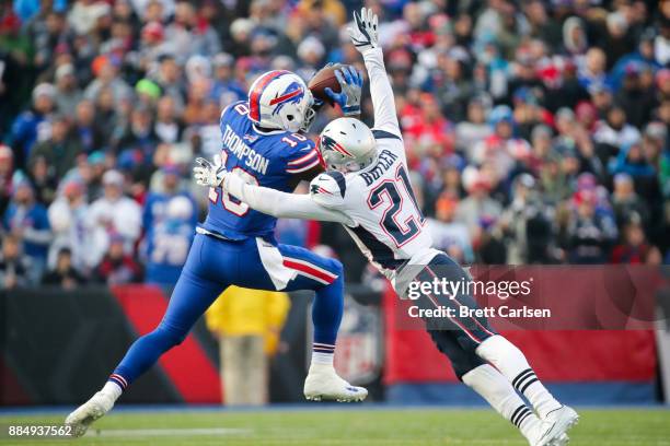 Deonte Thompson of the Buffalo Bills catches the ball as Malcolm Butler of the New England Patriots attempts to tackle him during the fourth quarter...