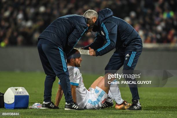 Medics apply a band-aid on Marseille's French forward Valere Germain's head after he was elbowed in the face, during the French L1 football match...