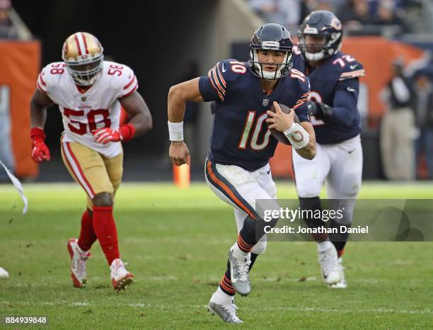 Mitchell Trubisky of the Chicago Bears runs for yardage in front of Elvis Dumervil of the San Francisco 49ers at Soldier Field on December 3, 2017 in...