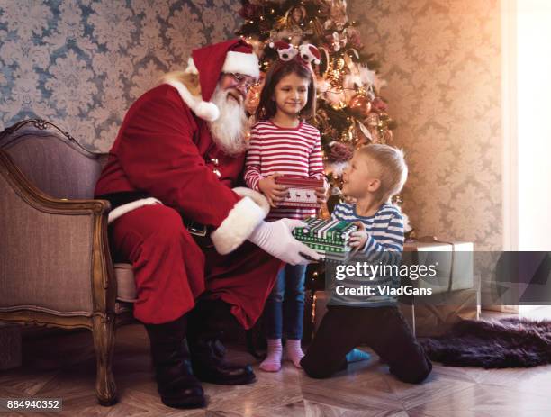 santa claus gives presents - santa hat and beard stock pictures, royalty-free photos & images
