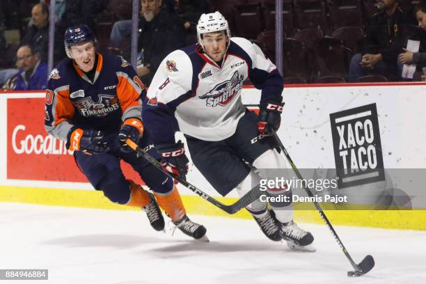 Defenceman Connor Corcoran of the Windsor Spitfires moves the puck against forward Connor Roberts of the Flint Firebirds on December 3, 2017 at the...