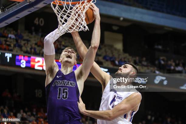 Center Philipp Hartwich of the Portland Pilots tries to shoot through the defensive pressure of forward Zach Haney of the Boise State Broncos during...