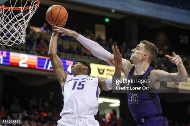 Guard Chandler Hutchison of the Boise State Broncos shoots for two through the defense of center Philipp Hartwich of the Portland Pilots pair during...