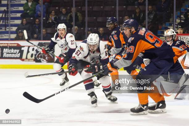 Forward Hunter Holmes of the Flint Firebirds moves the puck against forward Luke Boka of the Windsor Spitfires on December 3, 2017 at the WFCU Centre...