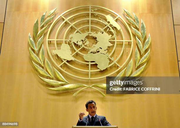 French President Nicolas Sarkozy gestures under a giant sign of the United Nations while delivering a speech before the International Labour...