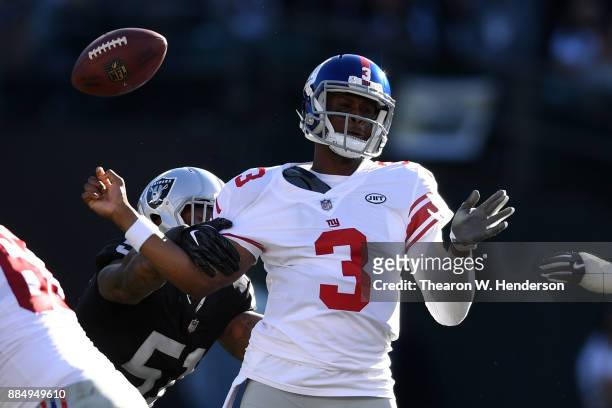 Geno Smith of the New York Giants is stripped of the ball by Bruce Irvin of the Oakland Raiders during their NFL game at Oakland-Alameda County...