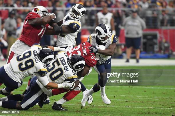 Running back Kerwynn Williams of the Arizona Cardinals is tackled by defensive end Aaron Donald, linebacker Samson Ebukam and free safety Lamarcus...