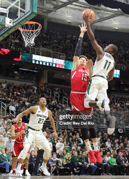 Lourawls Nairn Jr. #11 of the Michigan State Spartans shoots a layup against Isaiah Roby of the Nebraska Cornhuskers at Breslin Center on December 3,...