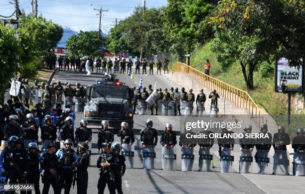 Soldiers and police block the road as thousands of supporters of the presidential candidate for Honduras' Opposition Alliance against the...