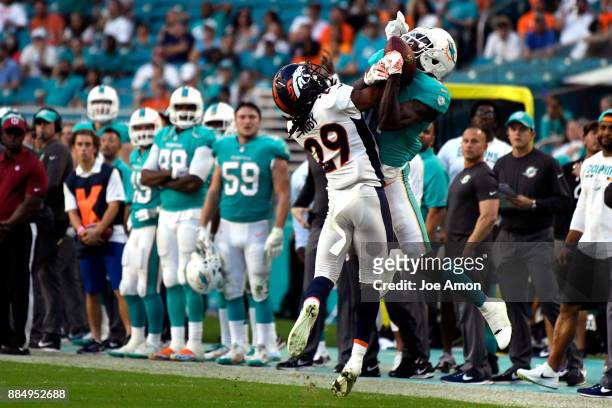 Free safety Bradley Roby of the Denver Broncos breaks up 3rd and 1 pass to wide receiver DeVante Parker of the Miami Dolphins in the 4th quarter as...