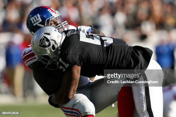 Orleans Darkwa of the New York Giants is tackled by Bruce Irvin of the Oakland Raiders during their NFL game at Oakland-Alameda County Coliseum on...