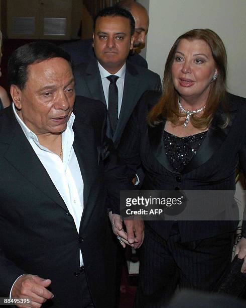 Egypt's veteran actor Adel Imam and his wife, Hala Shalaqani, arrive to the premiere of his latest film "Bobbos" at Cairo's Opera House late on June...