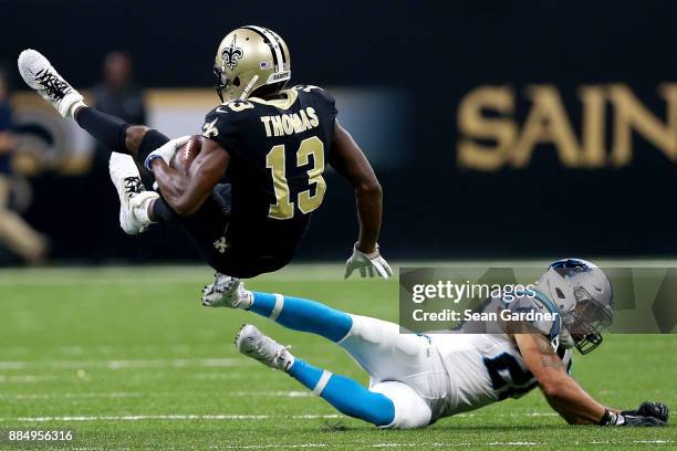 Michael Thomas of the New Orleans Saints is tackled by Kurt Coleman of the Carolina Panthers during the first half of a NFL game at the Mercedes-Benz...
