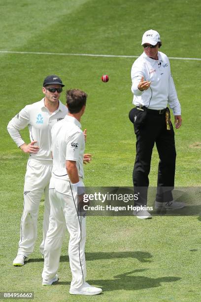 Umpire Rod Tucker of Australia delivers the new ball to Trent Boult of New Zealand during day four of the Test match series between New Zealand...