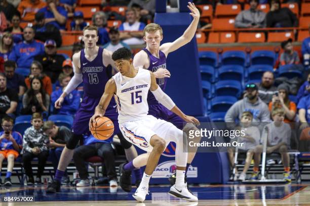 Guard Chandler Hutchison of the Boise State Broncos reverses direction around the defense of forward Josh McSwiggan of the Portland Pilots during...