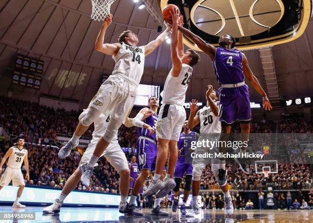 Ryan Cline and Grady Eifert of the Purdue Boilermakers battle for the rebound with Vic Law of the Northwestern Wildcats at Mackey Arena on December...