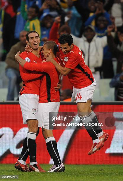 Egytpian forward Mohamed Aboutrika and Egyptian midfielder Sayed Moawad congratulate Egyptian forward Mohamed Zidan after the scored the third goal...
