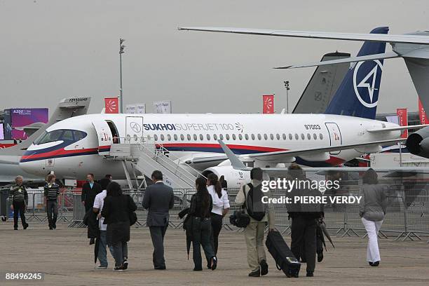 Visitors walk in front of the Russian Sukhoi Superjet 100 on June 15, 2009 during the week long 48th international Paris Air Show at Le Bourget...