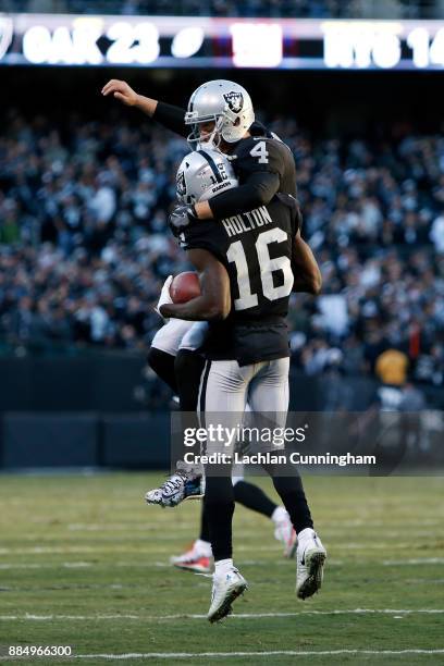 Derek Carr of the Oakland Raiders celebrates with Johnny Holton after a nine-yard touchdown pass in the fourth quarter of their NFL game against the...
