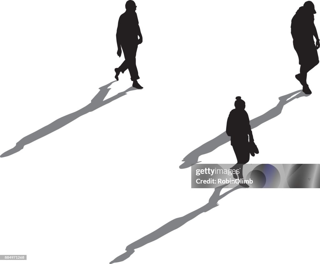 Three People Walking With Long Shadows