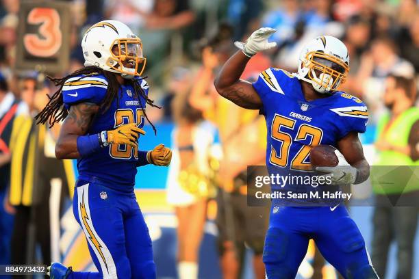 Tre Boston and Denzel Perryman of the Los Angeles Chargers react to recovering a fumble during the second half of a game against the Cleveland Browns...