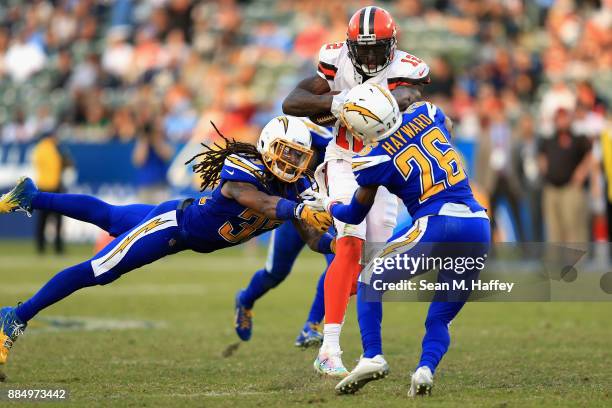 Casey Hayward and Tre Boston of the Los Angeles Chargers tackle Josh Gordon of the Cleveland Browns on a run play during the second half of a game at...