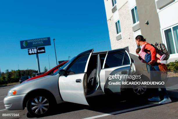 Deborah Oquendo boards her 10mo old daughter Genesis Rivera into her car at the hotel were they are staying in Orlando, Florida on December 1, 2017....