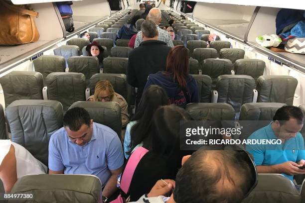 People board a flight to Orlando, Florida at a Luis Munoz Marin International Airport terminal in San Juan, Puerto Rico on November 30, 2017. On...