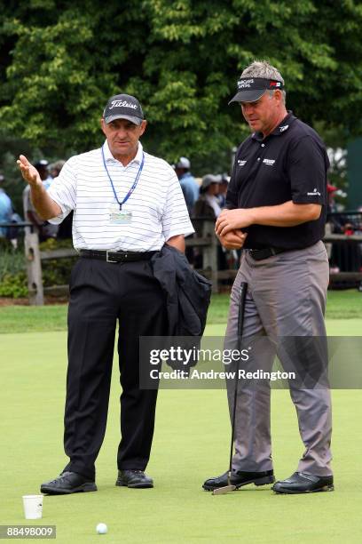 Darren Clarke of Northern Ireland talks with coach Bob Rotella during the first day of previews to the 109th U.S. Open on the Black Course at...