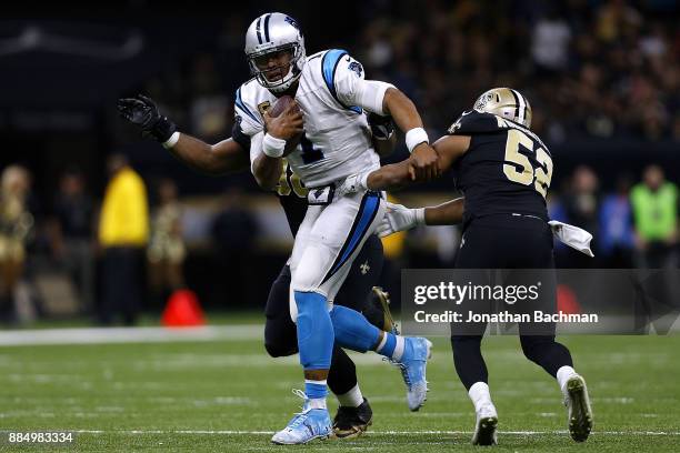 Cam Newton of the Carolina Panthers is tackled by Craig Robertson of the New Orleans Saints and Sheldon Rankins during the second half of a game at...