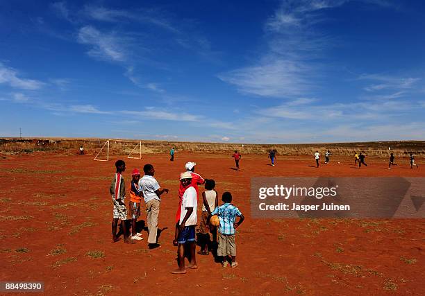 Kids watch others enjoying a game of football on June 15, 2009 in Mogale City, South Africa. Football fever is gripping South Africa as the world's...