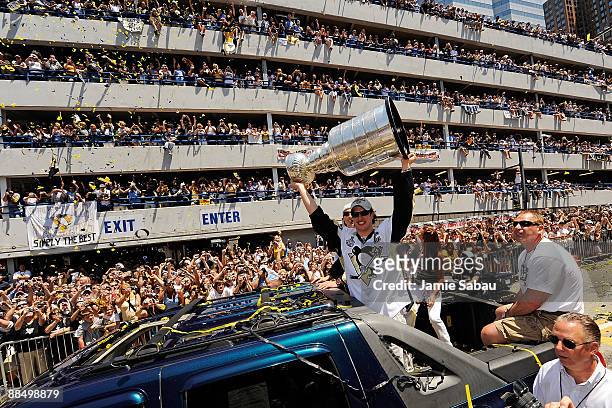 Sidney Crosby of the Pittsburgh Penguins holds the Stanley Cup aloft for the fans along the Blvd of the Allies during the Stanley Cup Champion...