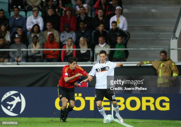 Mesut Oezil of Germany and Javi Martinez of Spain battle for the ball during the UEFA U21 Championship Group B match between Spain and Germany at the...