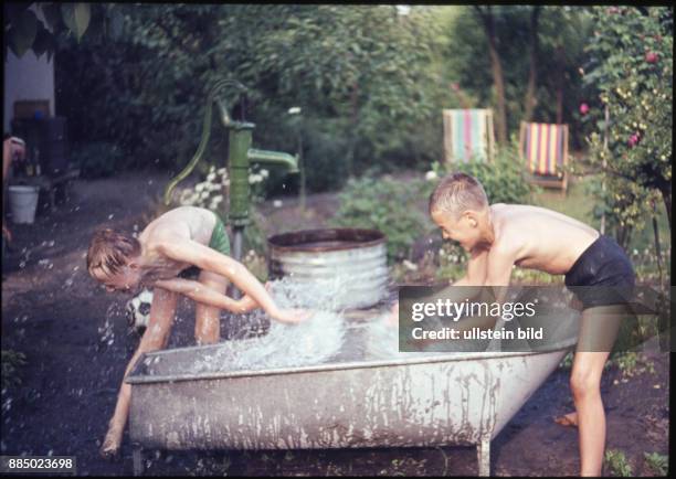 Aufnahme ca. 1950, Kindheit, Jungen spritzen im Garten mit Wasser