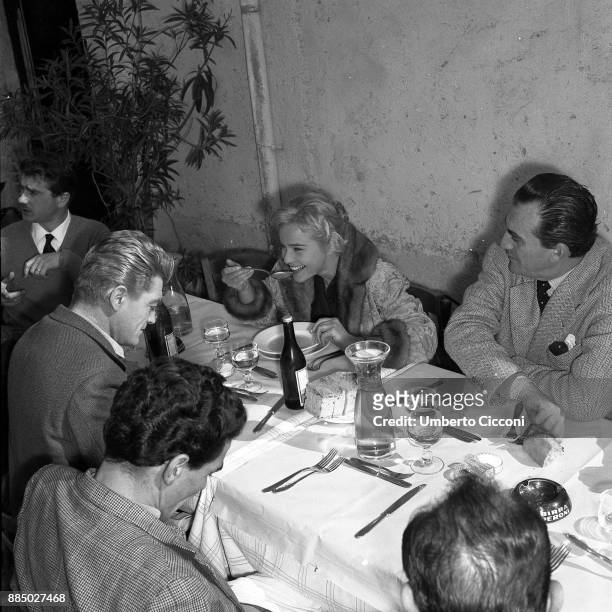 Actor Jean Marais, actress Maria Schell, director Luchino Visconti and other people during a lunch break while shooting the movie 'Le notti Bianche'...