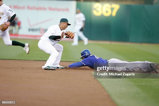 Nelson Cruz of the Texas Rangers slides safely into second base in front of Orlando Cabrera of the Oakland Athletics during the game at the Oakland...