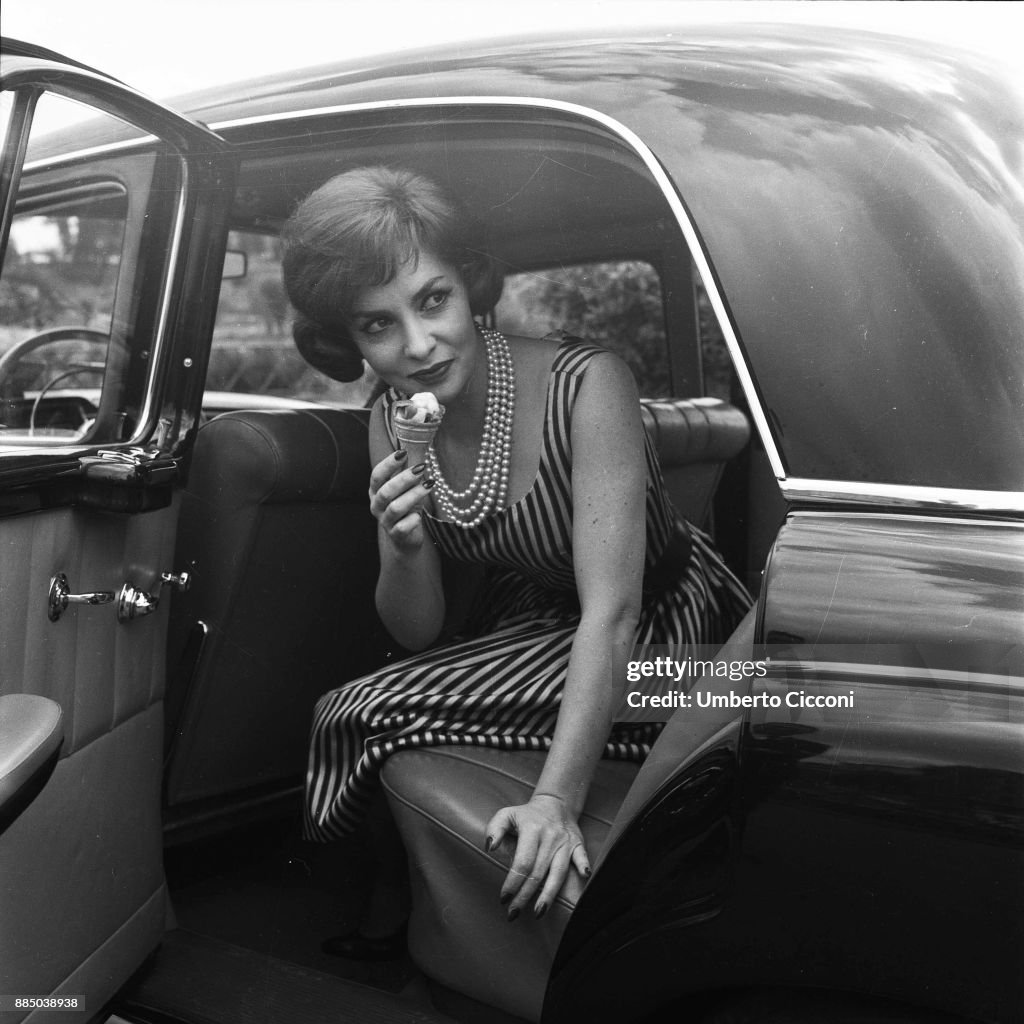 Italian actress Gina Lollobrigida eats an ice-cream in her car, Rome 1955