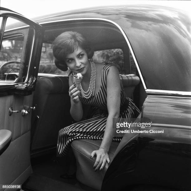 Italian actress Gina Lollobrigida eats an ice-cream in her car, Rome 1955.