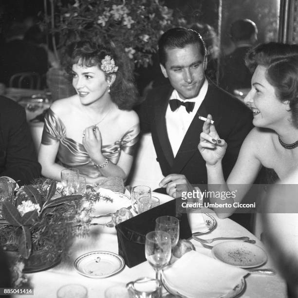 Italian actress Gina Lollobrigida with her husband Milko Skofic at dinner party, Rome 1955.