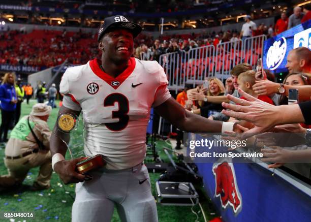 Georgia Bulldogs linebacker Roquan Smith reacts with fans while holding his Most Valuable Player trophy at the conclusion of the SEC Championship...