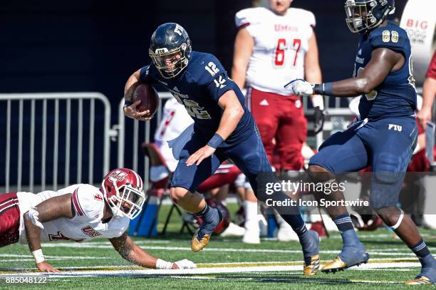 Quarterback Alex McGough evades UMass defensive lineman Da'Sean Downey while carrying the ball in the second quarter as the FIU Golden Panthers...