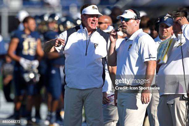 Football Head Coach Butch Davis speaks with an assistant in the fourth quarter as the FIU Golden Panthers defeated the University of Massachusetts...