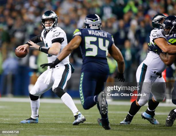 Quarterback Carson Wentz of the Philadelphia Eagles looks to pass under pressure from middle linebacker Bobby Wagner of the Seattle Seahawks in the...