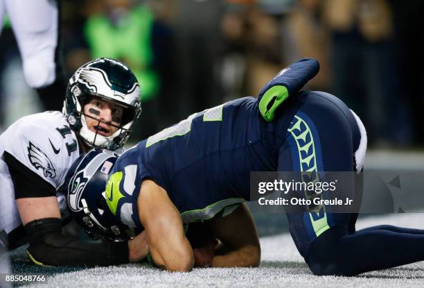 Quarterback Carson Wentz of the Philadelphia Eagles looks to a referee as linebacker Michael Wilhoite of the Seattle Seahawks tries to hold onto the...