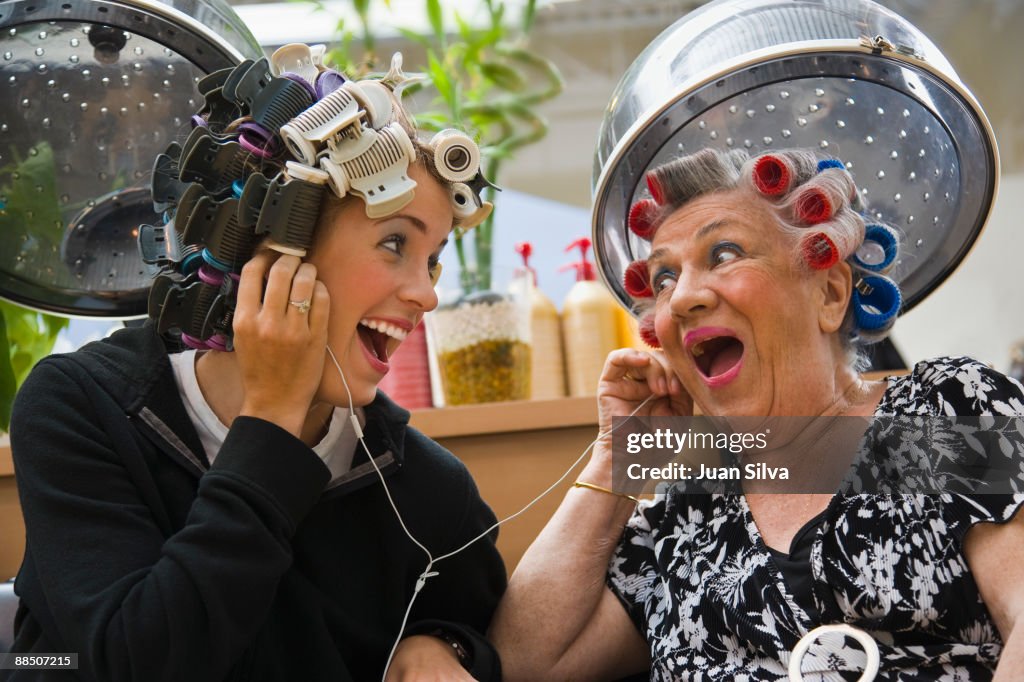 Older woman and young woman sharing headphone 