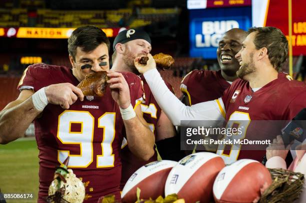 Quarterback Kirk Cousins and outside linebacker Ryan Kerrigan of the Washington Redskins eat turkey after the Redskins defeated the New York Giants...